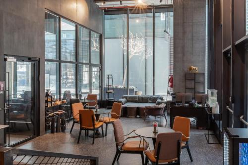 a large room with tables and chairs and windows at Play Midtown Hotel Tel Aviv in Tel Aviv