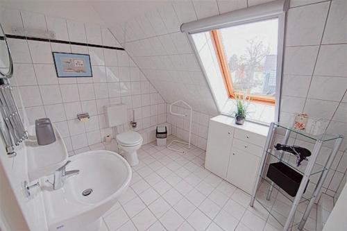biała łazienka z umywalką i toaletą w obiekcie Am Bodden, FW 8 w Zingst