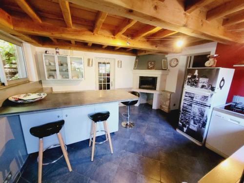 Velleronにあるla petite maison de velleronのキッチン(カウンター、スツール2つ付)