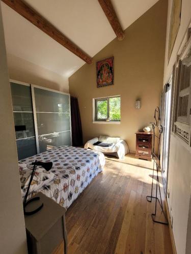 une chambre avec un lit et une fenêtre dans l'établissement la petite maison de velleron, à Velleron