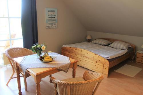 1 dormitorio con 1 cama, mesa y sillas en "Pappelhof - Whg 6", en Grömitz