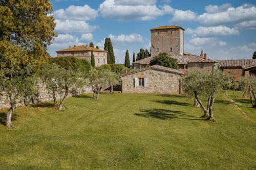a large yard with trees and a castle at Borgo Scopeto Wine & Country Relais in Vagliagli