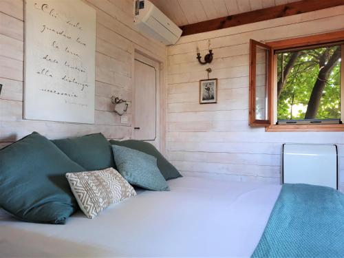 a bed in a wooden room with a window at Casa sull'Albero Aromantica in San Salvatore Monferrato
