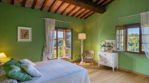 um quarto com paredes verdes, uma cama e janelas em La Villa nell'Isola Verde 12, Emma Villas em Casciana Terme