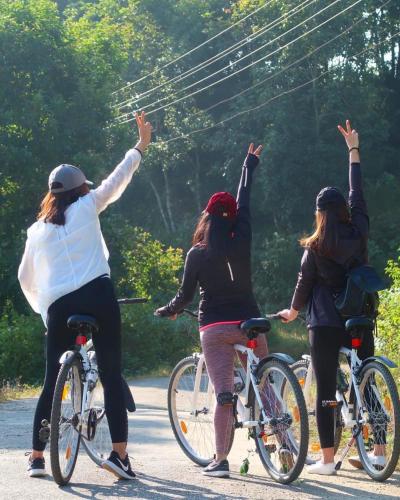 a group of women riding bikes down a road at THE GINGKO EYRIE in Kalimpong
