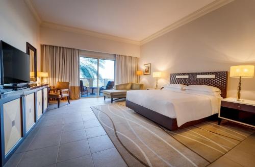 a hotel room with a bed and a television at Grand Hyatt Doha Hotel & Villas in Doha