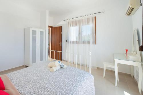 a bedroom with a bed with a teddy bear on it at Cosy House in Kiotari with Garden and Terrace in Kiotari
