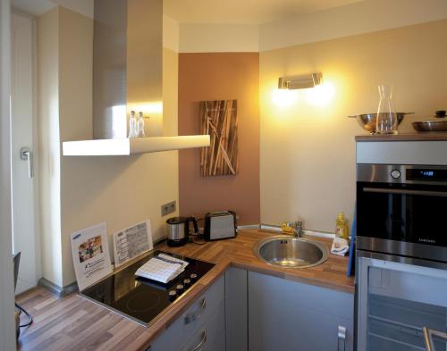 a small kitchen with a sink and a microwave at ancora Marina Haus 2 Nr 04, Typ 1 in Neustadt in Holstein