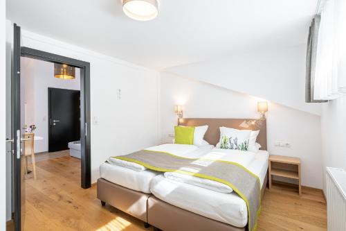 a bedroom with a large bed with white walls at Edelweiss Apartments 200m zum Lift - Silvretta Card Premium Inklusive in See