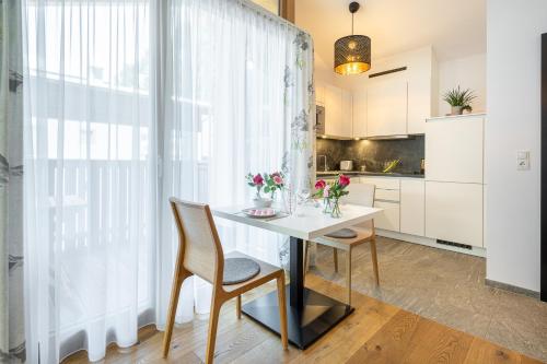 a kitchen with a table and chairs and a window at Edelweiss Apartments 200m zum Lift - Silvretta Card Premium Inklusive in See