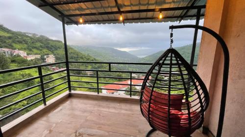 a hammock on a balcony with a view of the mountains at Belle-Vue Holiday Homes - 1BHK Apartments in Panchgani
