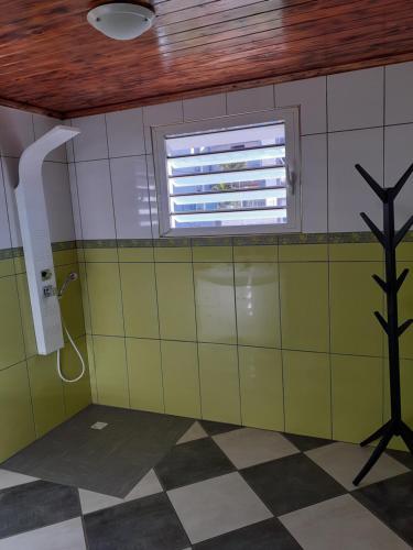 a bathroom with a window and a tiled wall at La perle des montagnes in Cilaos