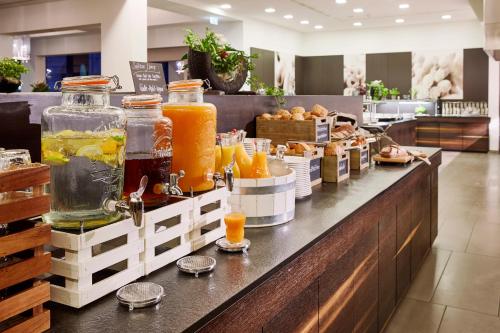 ein Buffet mit vielen Gläsern Orangensaft in der Unterkunft Lindner Hotel Nurburgring Motorsport, part of JdV by Hyatt in Nürburg