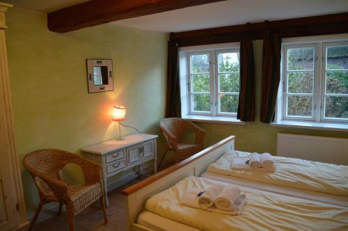 a bedroom with two beds and a table and two chairs at Altenteil in Oldsum