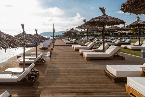 a row of lounge chairs and umbrellas on a beach at Pepper Sea Club Hotel in Georgioupolis