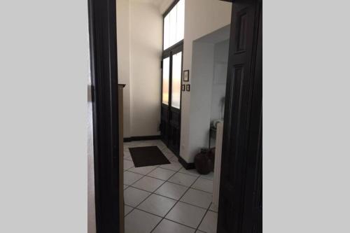 korytarz z drzwiami prowadzącymi do łazienki z podłogą wyłożoną kafelkami w obiekcie Villa Kunterbunt w mieście Iserlohn