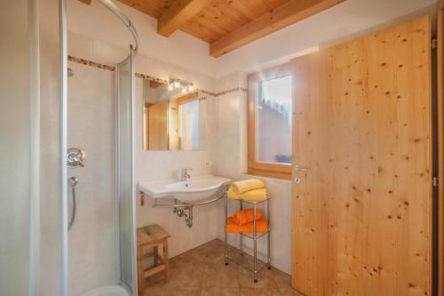 a bathroom with a sink and a shower at Tonigbauernhof Enzian in Schenna