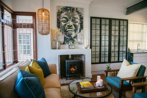 a living room with a couch and a fireplace at La Maison On Main Self-Catering Villa in Paarl
