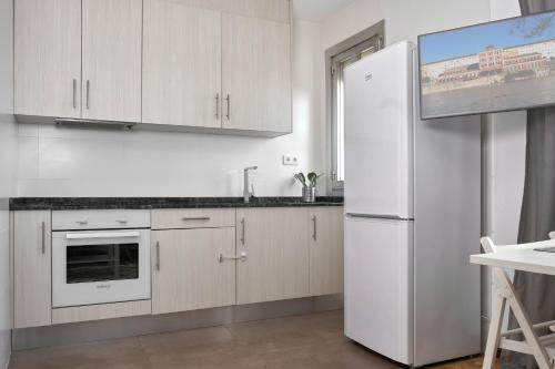 a kitchen with white cabinets and a refrigerator at Apartamento El Coso in Logroño