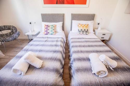 - 2 lits dans une chambre avec des serviettes à l'étage dans l'établissement Sublime trois pièces proche Monaco, à Beausoleil