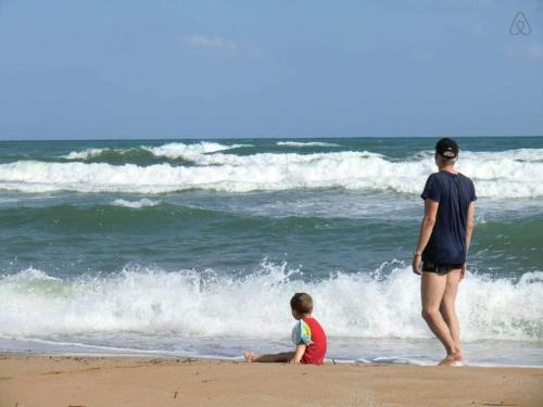 a man and a child on the beach with the ocean at Alkionis Beach Hotel Apartments in Sfakaki