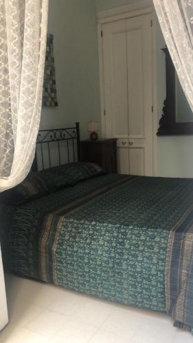 um quarto com uma cama com um edredão verde em La stanza di Zeza em Nápoles