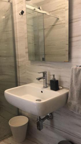 uma casa de banho com um lavatório branco e um espelho. em La stanza di Zeza em Nápoles