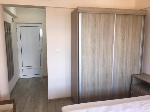 a bedroom with a large wooden closet with a door at Cazare Hofmann in Arad