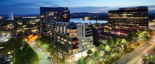 an overhead view of a city with buildings and a river at Nishi Holiday Apartments in Canberra
