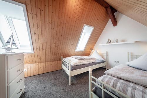 a bedroom with two beds and two windows at "Villa Anker" Dachgeschoss - links in Fehmarn