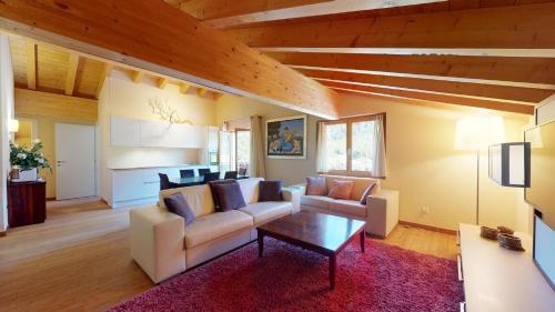 a living room with a couch and a table at Chesa Seraina Abitaziun Seraina 9 - Mahogany - Madulain in Madulain