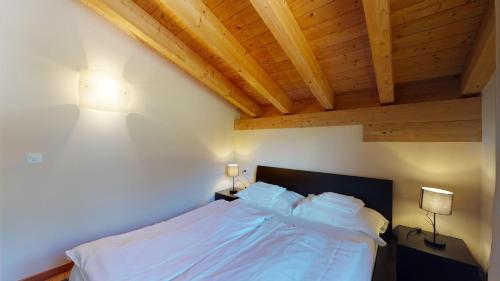 a bedroom with a bed with a wooden ceiling at Chesa Seraina Abitaziun Seraina 9 - Mahogany - Madulain in Madulain