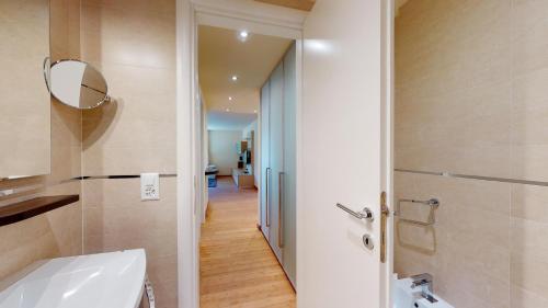a bathroom with a white toilet and a mirror at Chesa Seraina Abitaziun Seraina 6 - Amber - Madulain in Madulain
