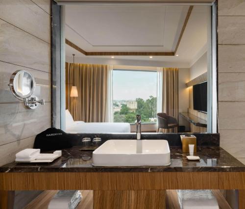 a bathroom with a sink and a large mirror at Radisson Bhopal in Bhopal