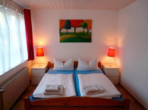 ハーフクルークにあるLandhaus-Marwede App 4のベッドルーム1室(ランプ2つ、絵画付)