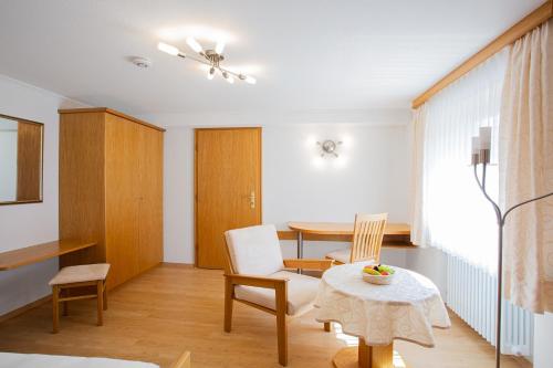 a living room with a table and chairs and a table at Gästehaus Prinzregent Luitpold in Bad Steben