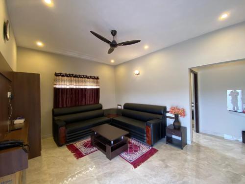 a living room with a couch and a ceiling fan at RR Holidays in Kodaikānāl