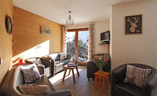 un salon avec un canapé, des chaises et une fenêtre dans l'établissement Odalys Chalet Sabot de Venus, à Les Deux Alpes