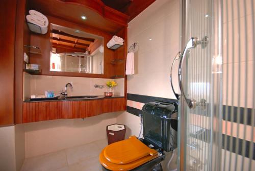 a bathroom with a shower with a toilet and a sink at Sterling Houseboats Lake Palace, Alleppey in Alleppey