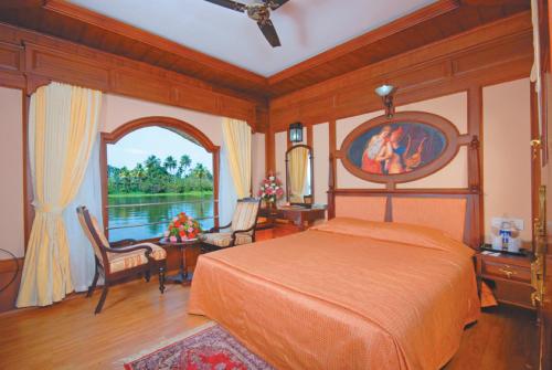a bedroom with a bed and a large window at Sterling Houseboats Lake Palace, Alleppey in Alleppey