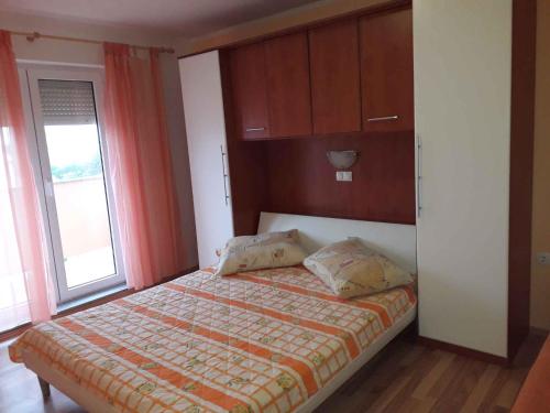 a bedroom with a bed and a window at Lopar Apartment 3 in Lopar