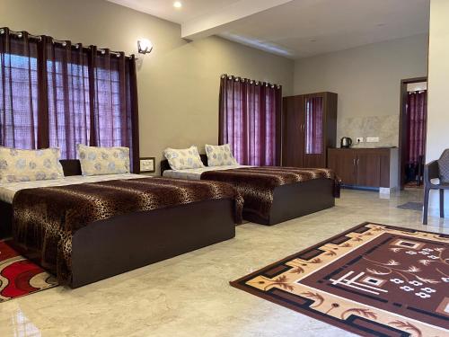 um quarto grande com 2 camas e um sofá em RR Holidays em Kodaikanal