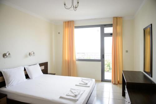 une chambre avec un lit et une grande fenêtre dans l'établissement Gardenia Vacation Settlement, à Sozopol