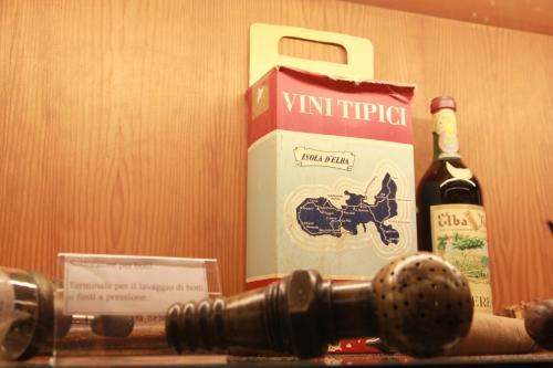 a bottle of wine and a microphone next to a box at Azienda Agricola Sapereta in Porto Azzurro