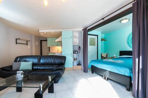 een woonkamer met een bed en een bank bij Studio De Groene Golf in Middelkerke