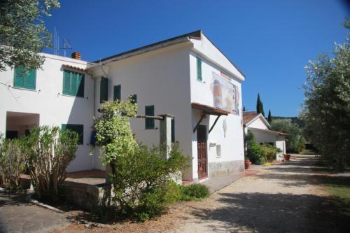 a white house with green shutters on it at Azienda Agricola Sapereta in Porto Azzurro