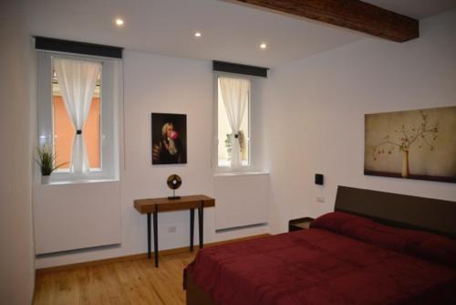 1 dormitorio con 1 cama roja y 2 ventanas en Fidia Palace Flavia's apartment Colosseo en Roma