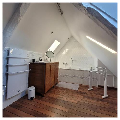 Gîte de charme au Manoir du Plessis-Quinquis في Sainte-Sève: غرفة علوية مع حوض استحمام ومغسلة