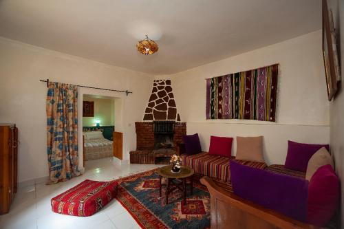 a living room with a couch and a fireplace at Auberge le Maquis in Aghbalou