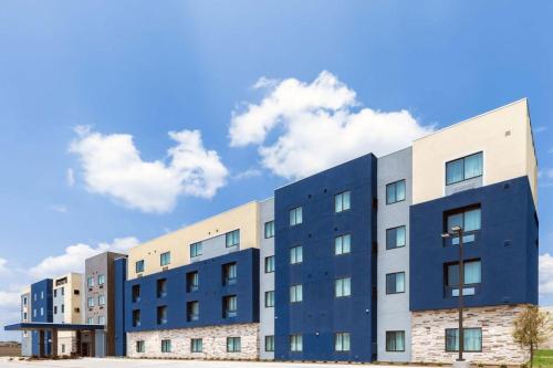a row of buildings in front of a blue at Staybridge Suites Waco South - Woodway by IHG in Woodway